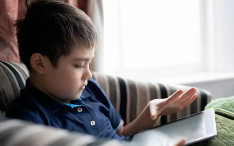 sad child with tablet family room daylight