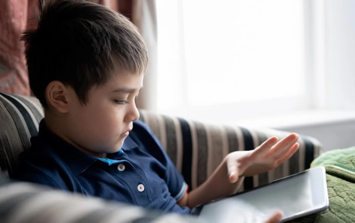 sad child with tablet family room daylight