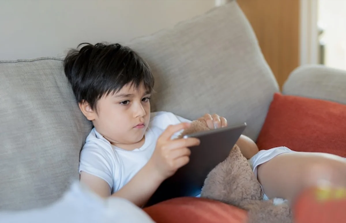 child sad with tablet livingroom