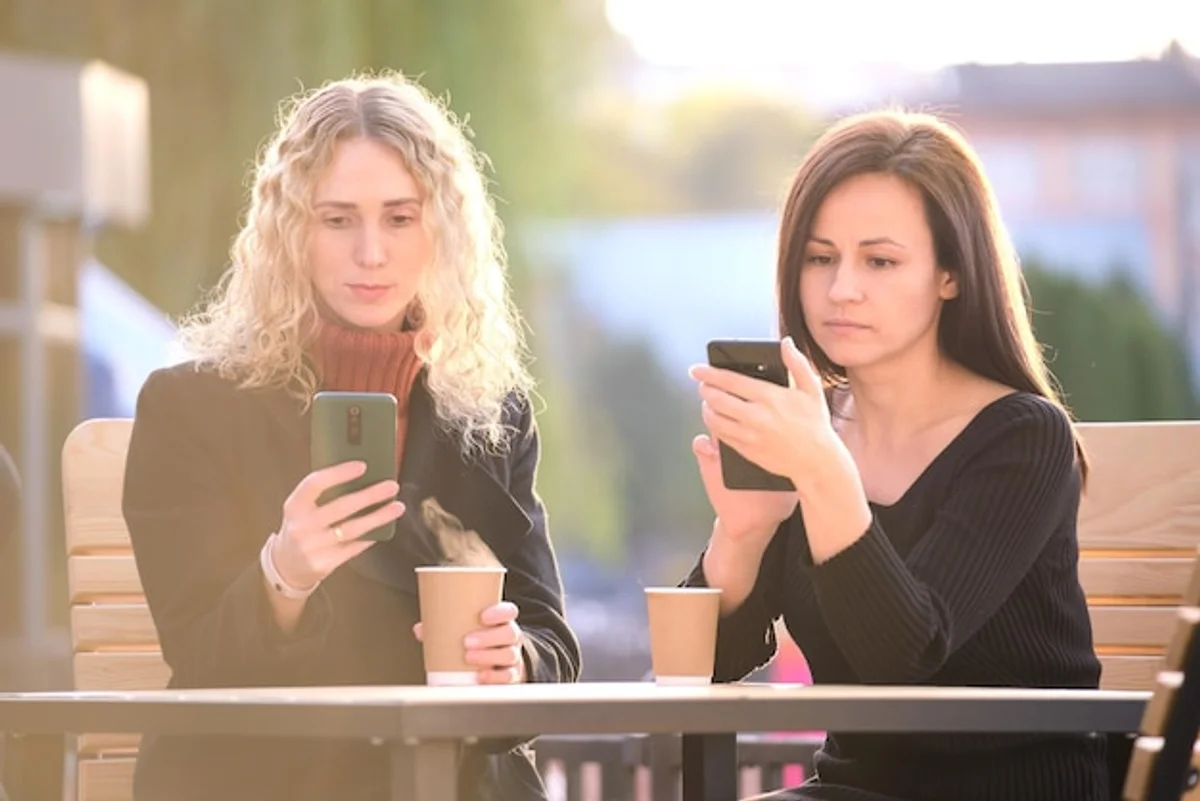 friends talking distracted by smartphones in coffee shop