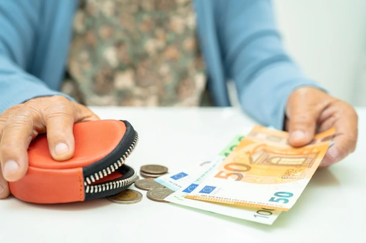 happy young adult saving money euro coins hands german bank