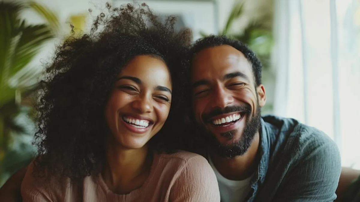 happy couple laughing cozy living room warm light