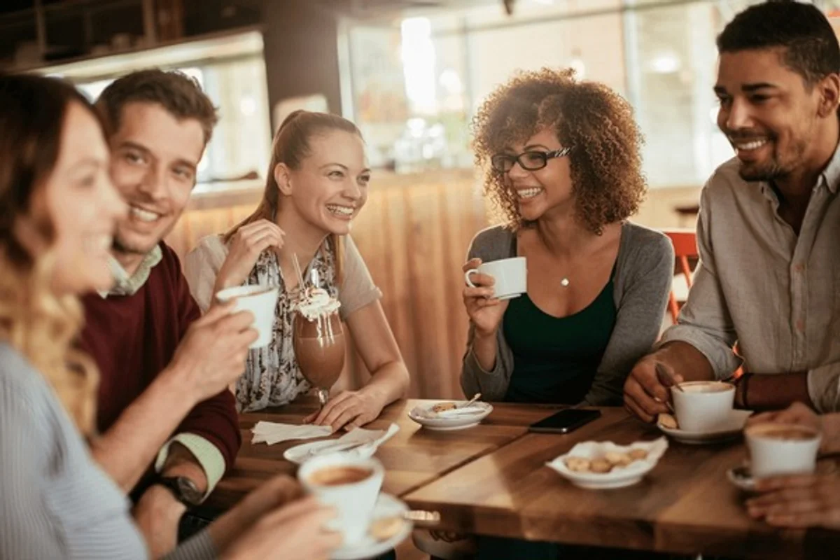 friends having coffee in cafe, candid, laughing, urban germany
