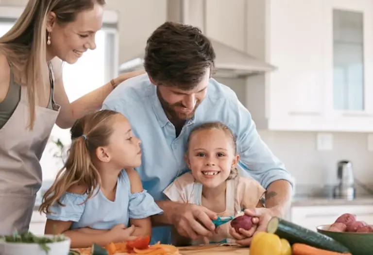 child cooking vegetables with parents kitchen