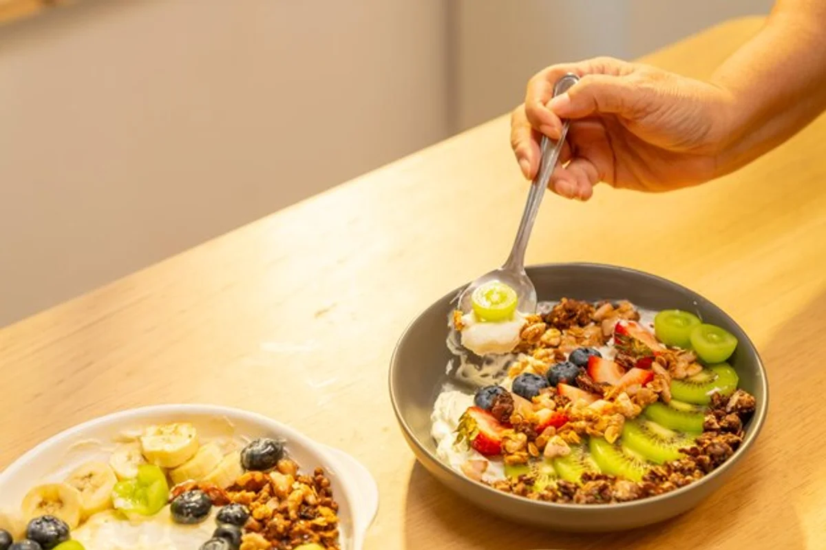 healthy senior eating blueberry yogurt breakfast table