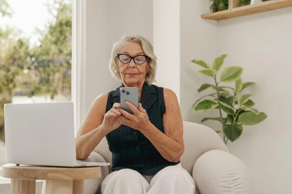 elderly person using smartphone comfortably home