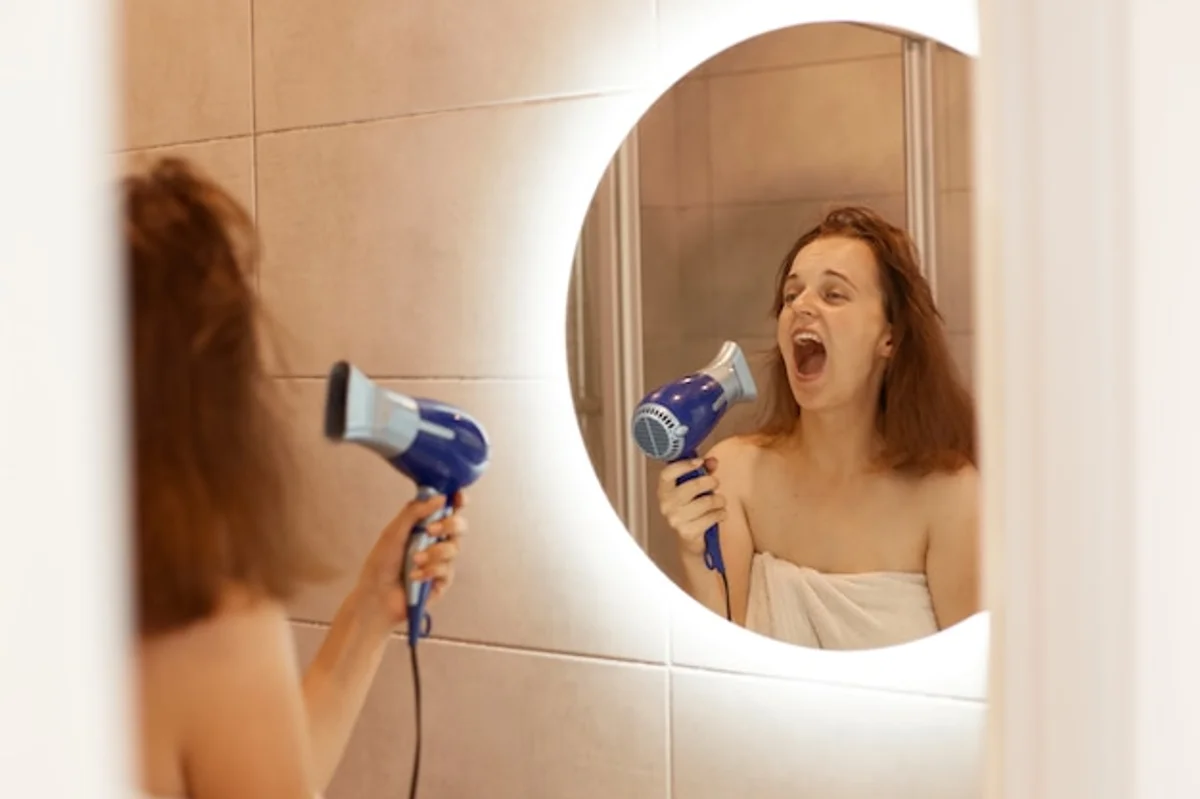 woman examining dry hair in the bathroom
