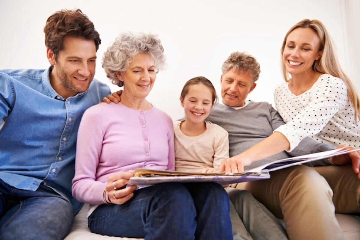 multi generational family looking at old photos together home