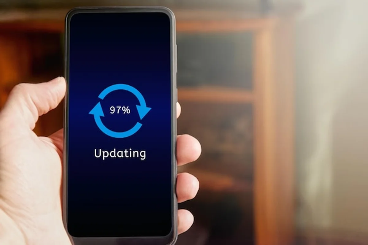 man holding smartphone with update icon on screen