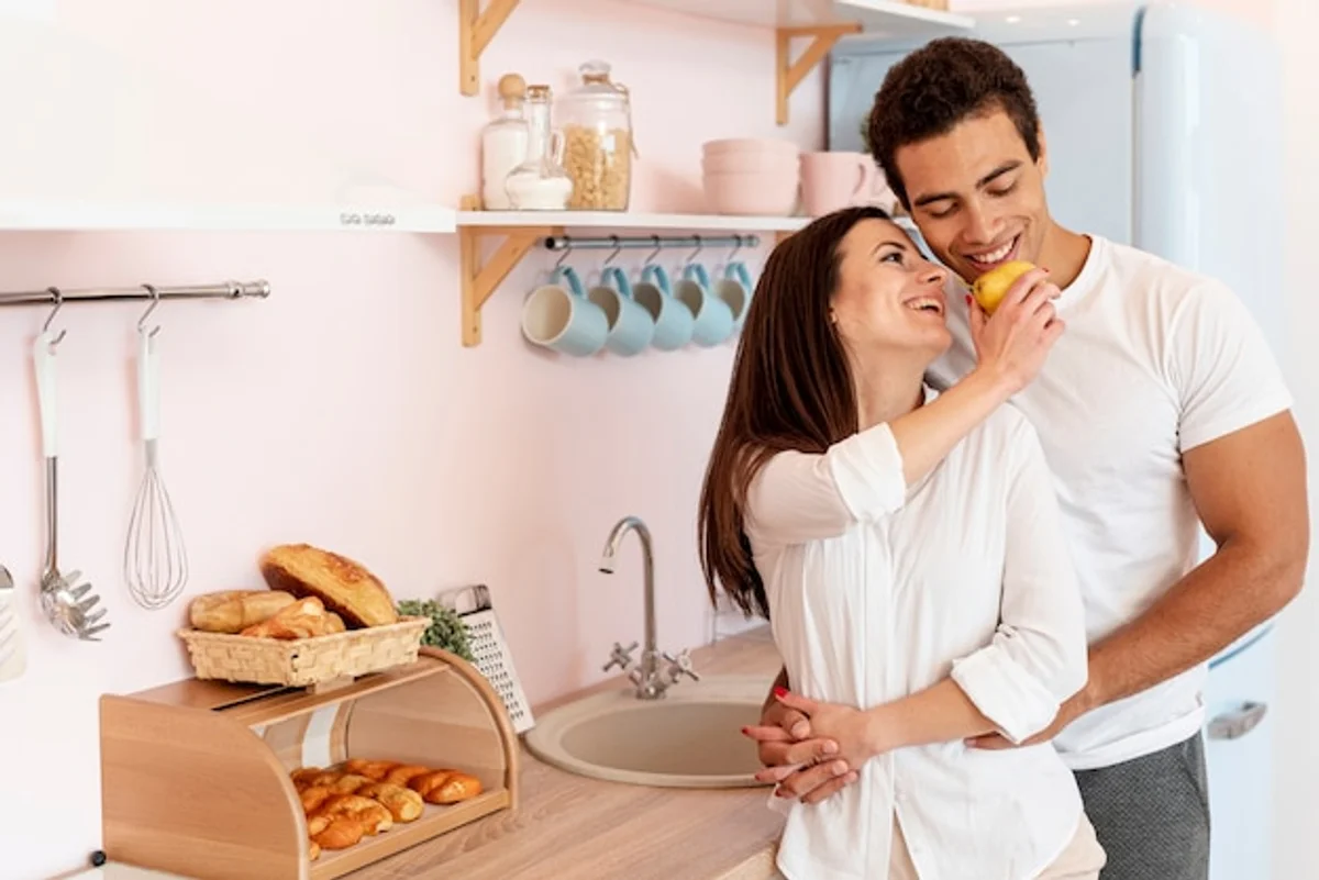 couple smiling and holding hands in kitchen