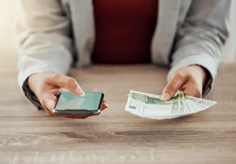 man holding reusable coffee cup with euro bills close up