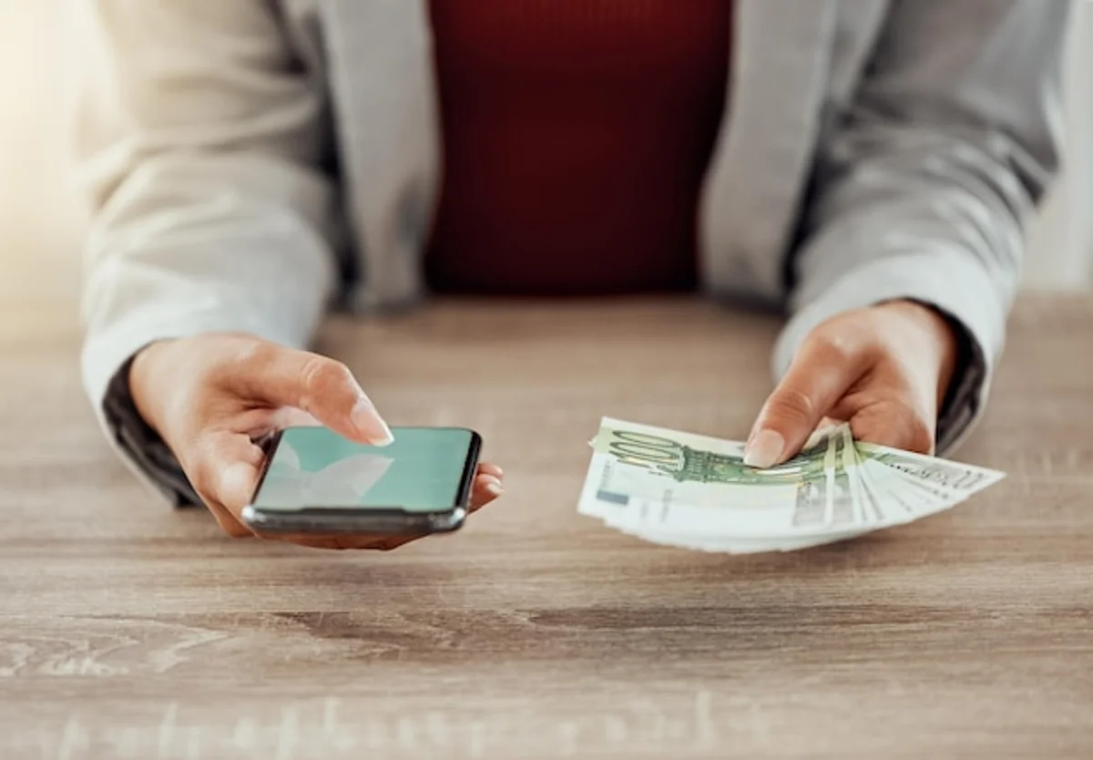 man holding reusable coffee cup with euro bills close up