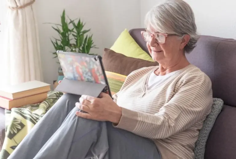 senior using tablet at home bright living room