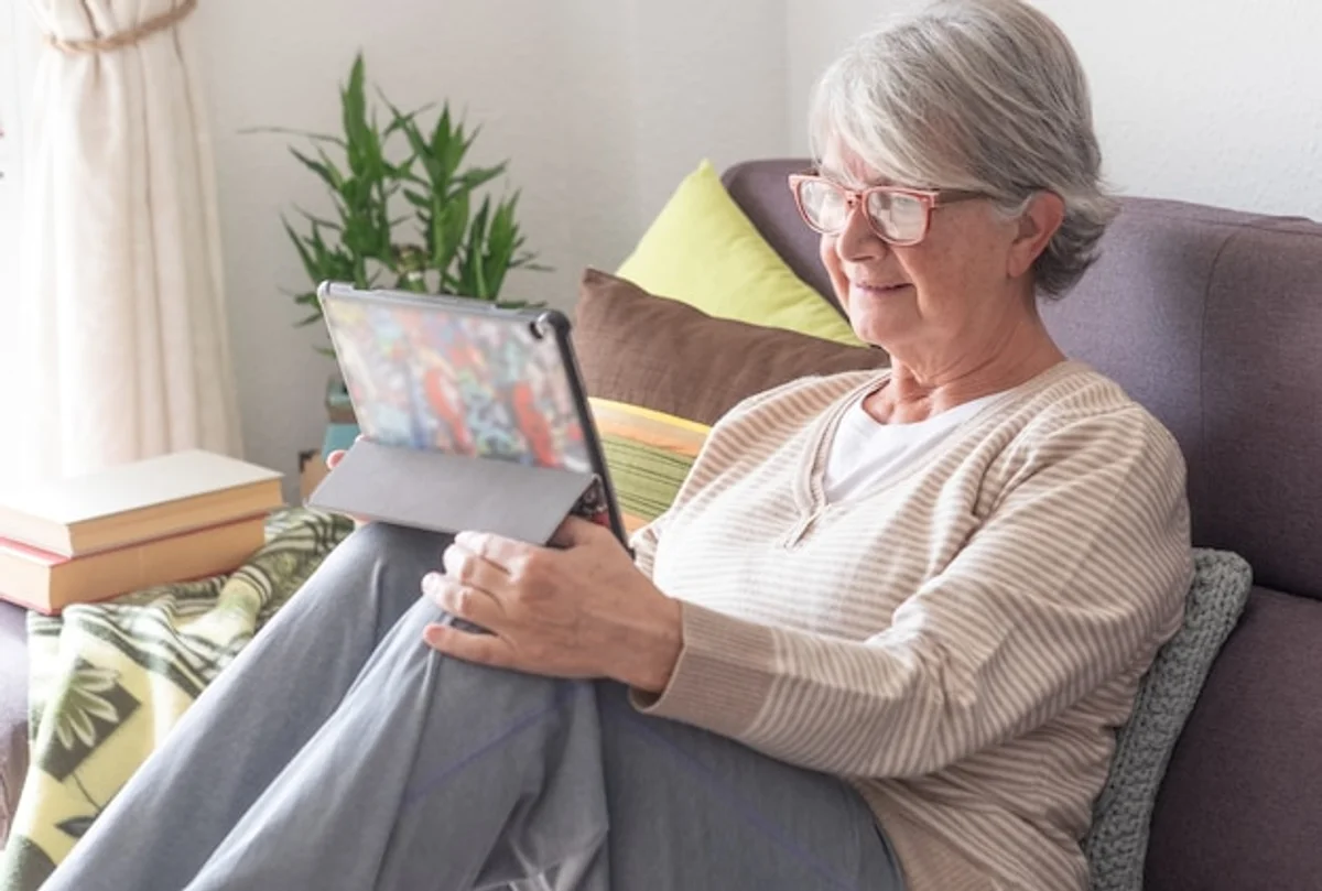senior using tablet at home bright living room