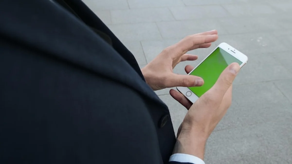 man checking smartphone battery settings outdoors