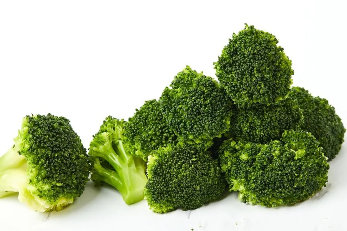 fresh broccoli florets on white background close up