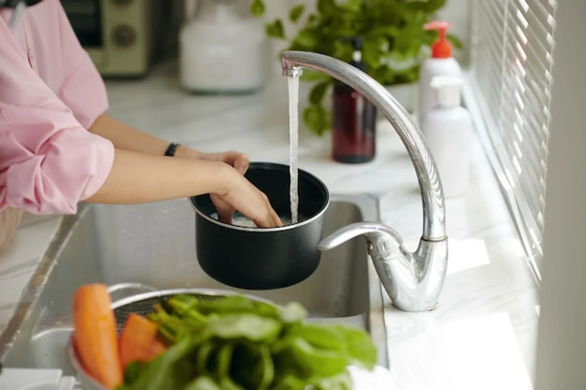 pouring pasta from pot into colander in kitchen close up