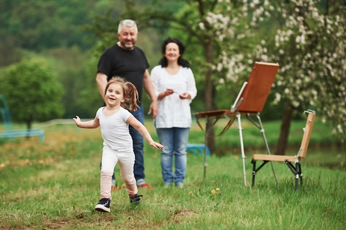 happy older parents and young children laughing together outdoor picnic germany