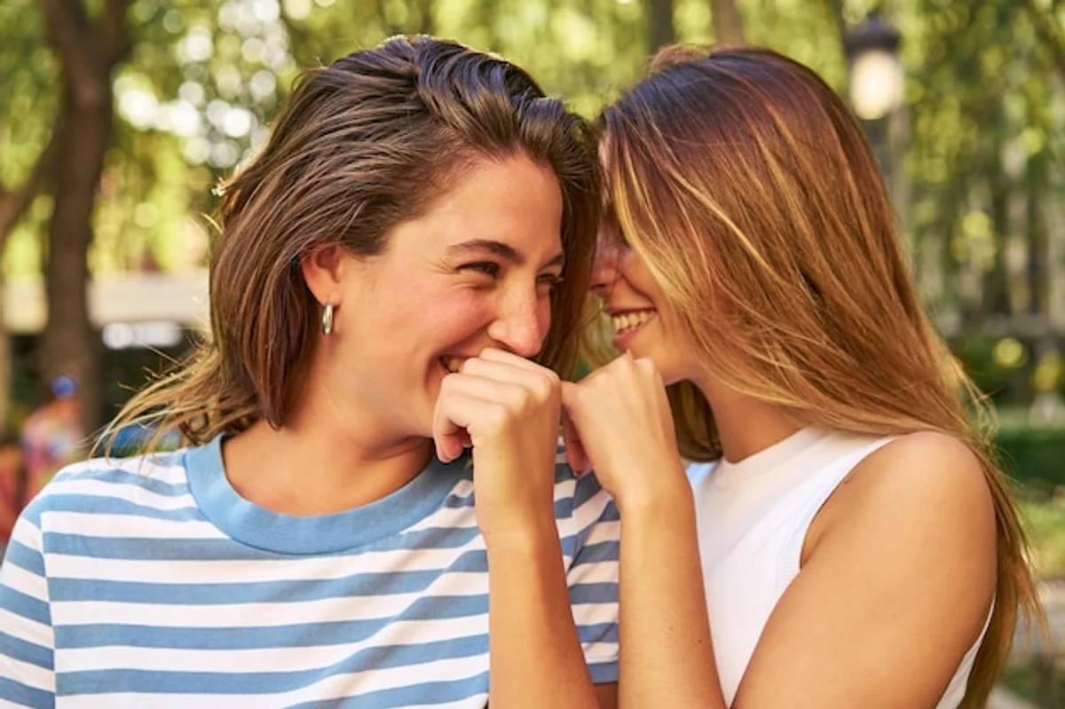 couple laughing together sharing secrets in park