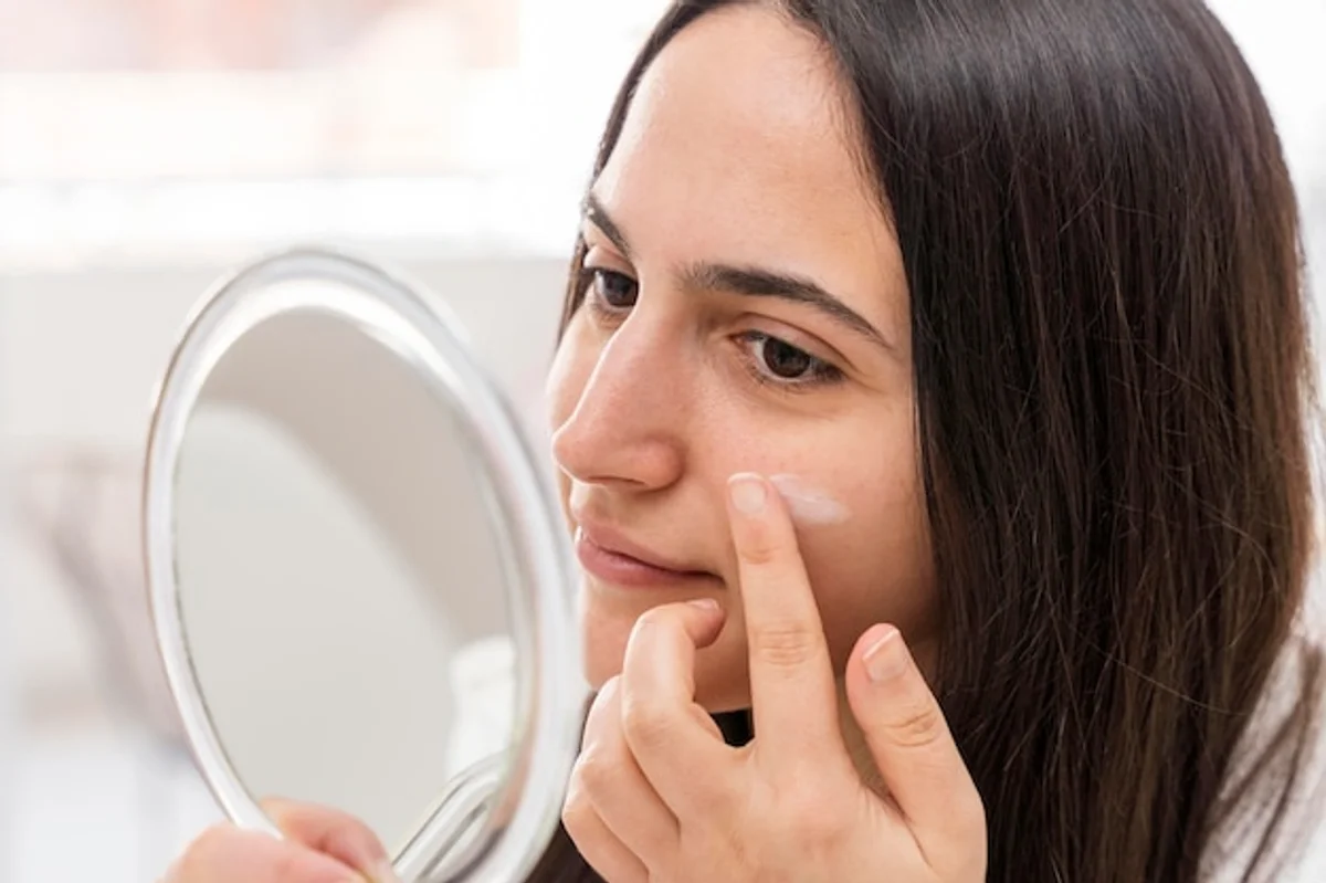 close up woman applying organic face cream