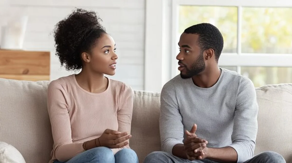 couple talking attentively on sofa living room cozy conversation