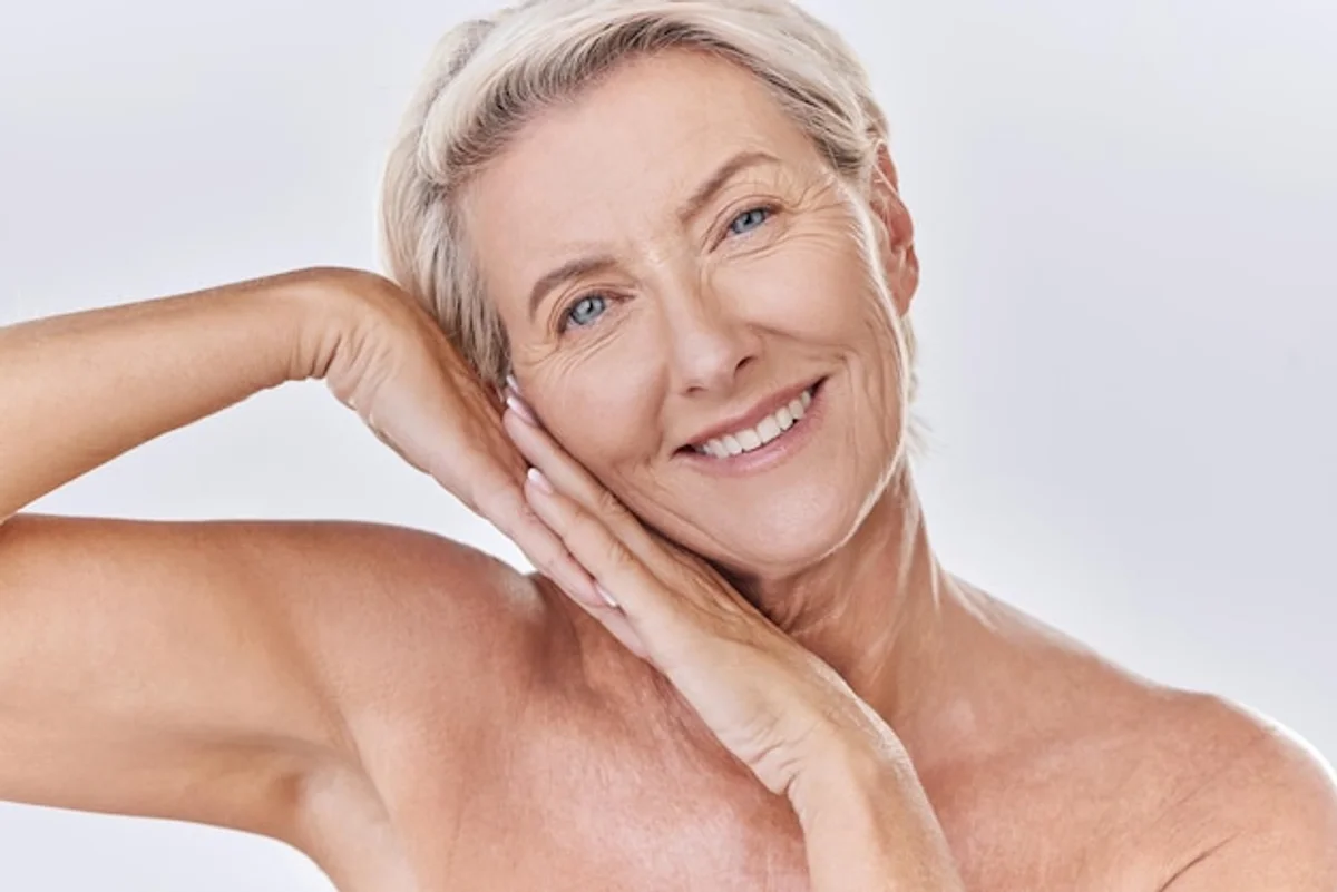 woman applying sunscreen mature smiling outdoor face closeup