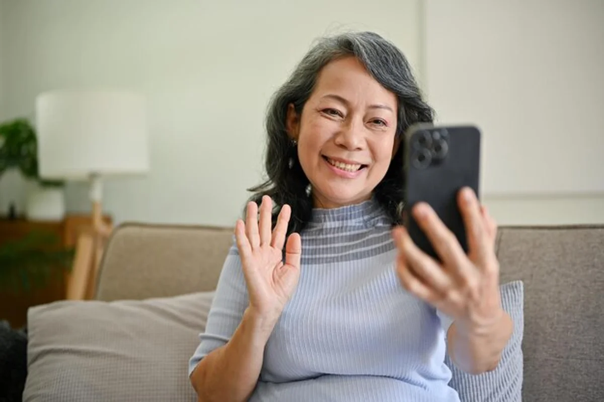 senior woman using smartphone video call grandchildren happy