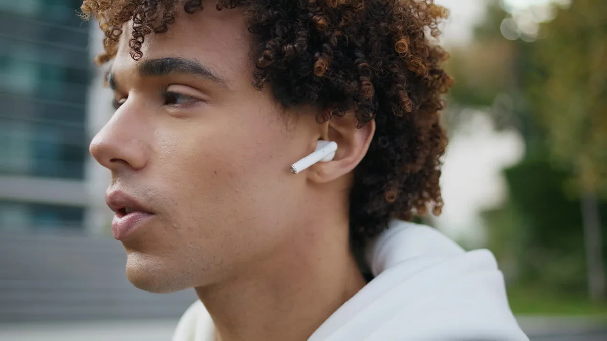 person struggling to pair bluetooth headphones with phone in urban setting