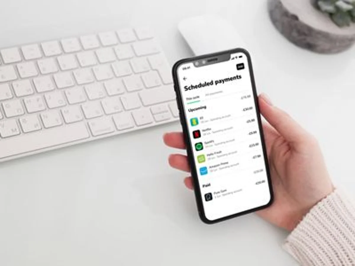 prepaid debit card and smartphone budgeting app in a German kitchen
