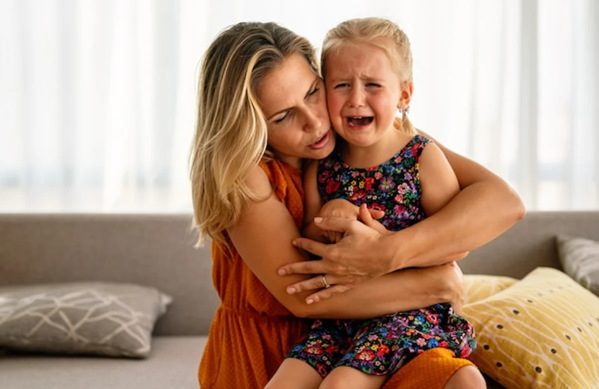 toddler crying parent comforting stock photo