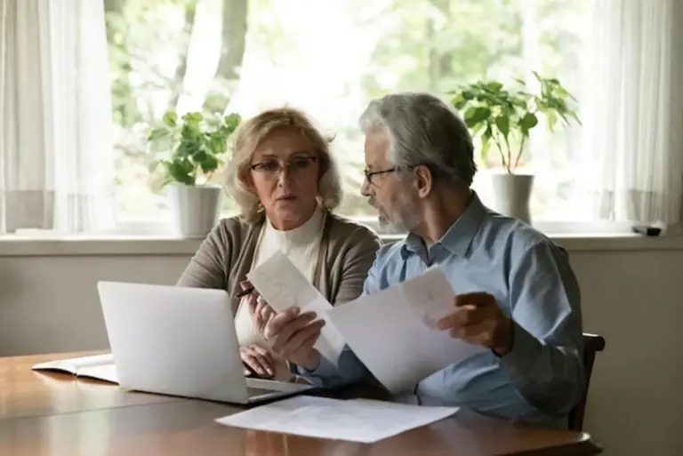 elderly couple reviewing financial plans at home