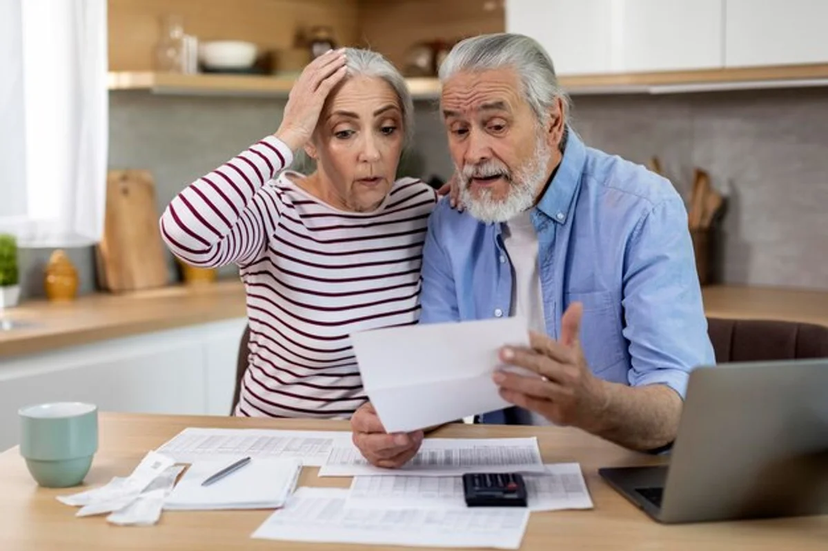 elderly couple looking at financial documents at home