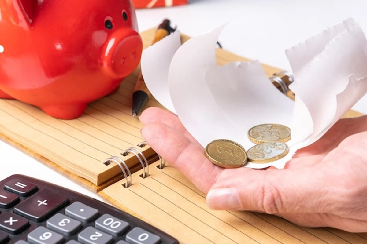 senior holding piggy bank and calculator