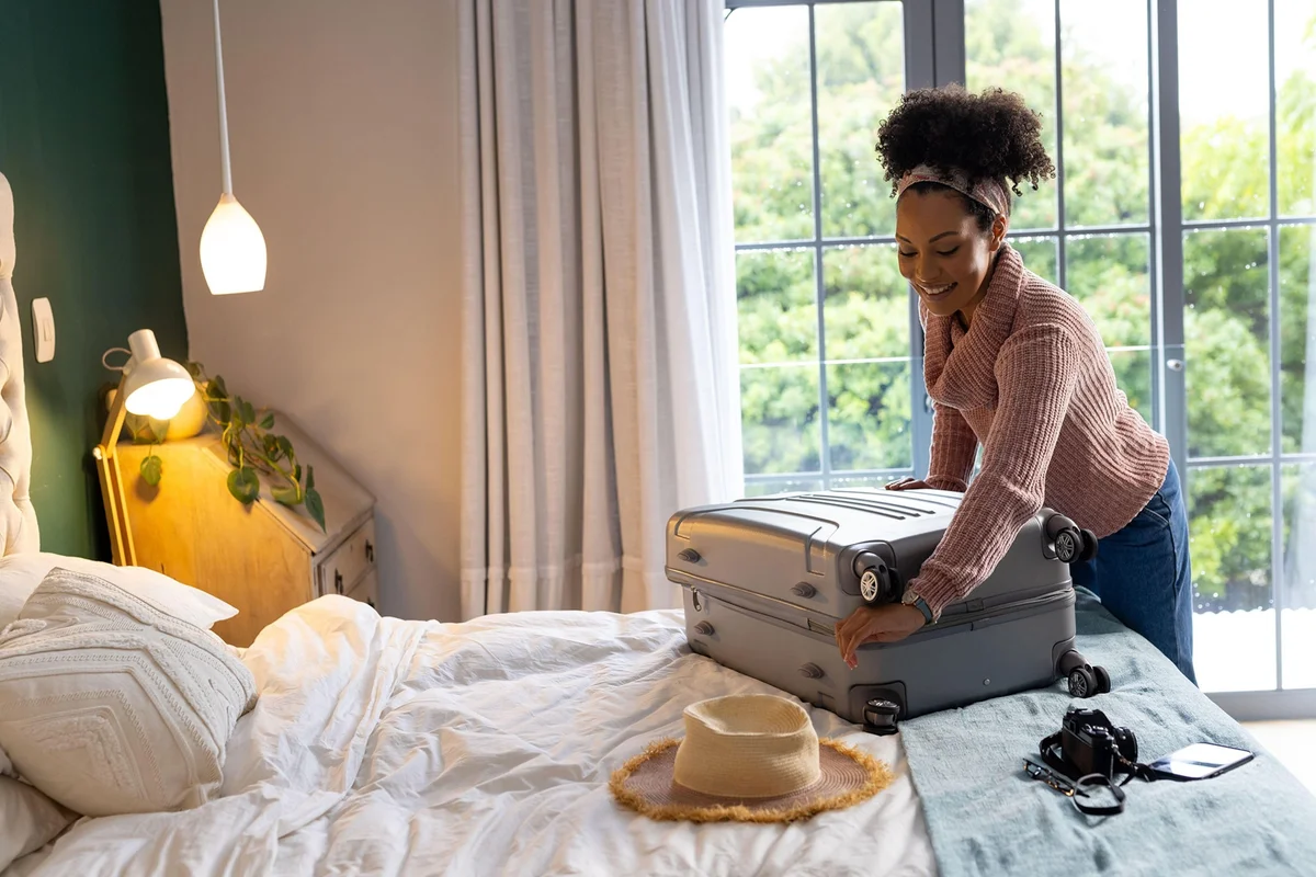 woman packing flexible travel bag with cubes hotel room